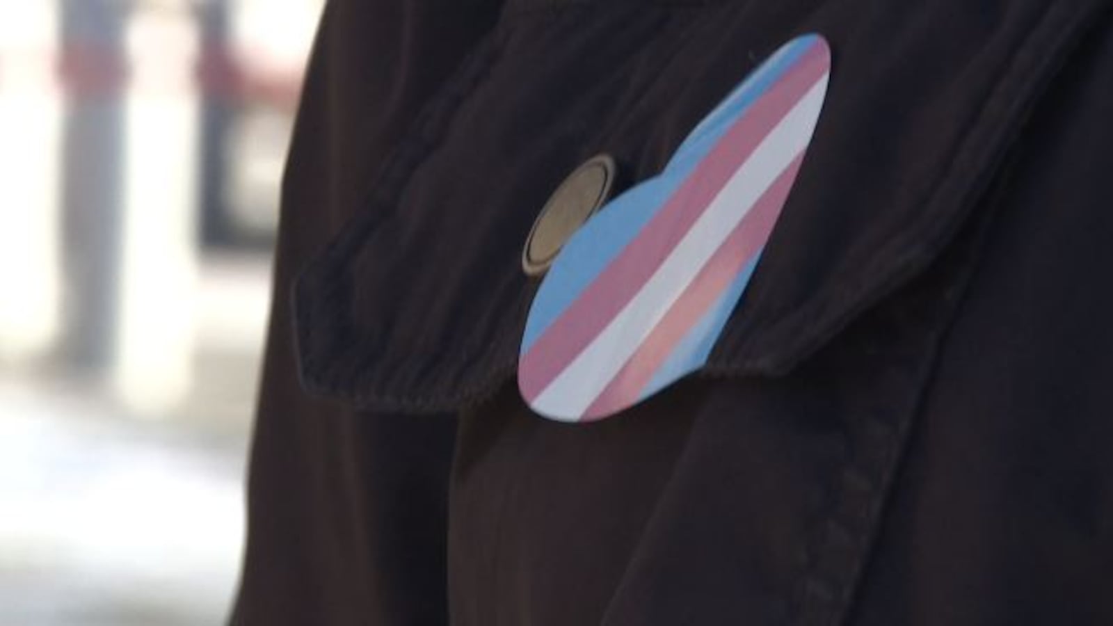 File - A person with a trans flag pin