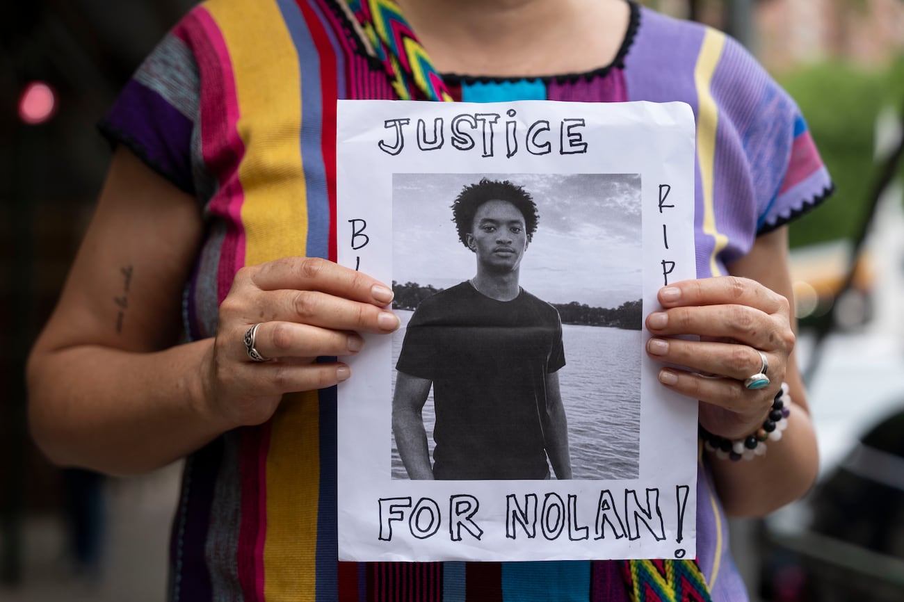 FILE - A person holds a picture of Nolan Xavier Wells during a news conference at National...